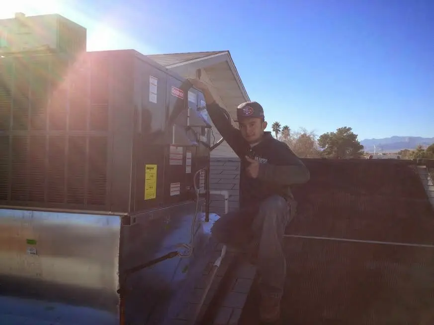 HVAC technician performing AC Tune-Up on a rooftop unit in Rossford